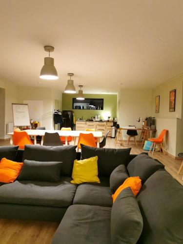 - un salon avec un canapé et des oreillers colorés dans l'établissement Maison de Charme, à Saint-Georges-des-Agoûts