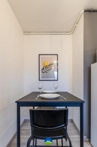 a table with two wine glasses and a chair at CATTENOM NEW NOVÝ NOWY НОВИЙ - 3 min Parking, Wi-Fi, Nespresso - Repos assuré, calme & confort - Rest guaranteed, quiet & comfy in Hayange