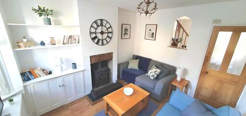 a living room with a blue couch and a fireplace at Meadvale - Lovely 3 Bed Victorian House in Reigate