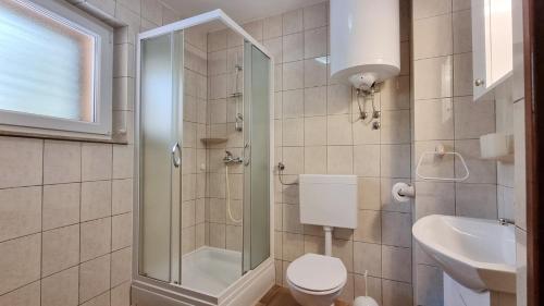 Un baño con ducha, inodoro y lavabo. en Apartments Barbalic D, en Baška