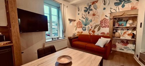 un salon avec un canapé et une télévision dans l'établissement Le bouquet 6 personnes max, à Éveux
