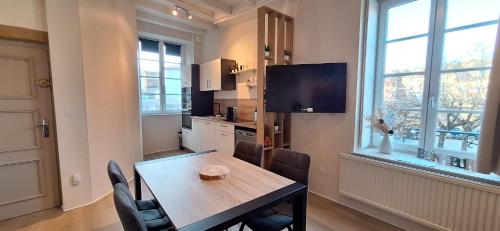 une cuisine avec une table de salle à manger et une télévision dans l'établissement Le bouquet 6 personnes max, à Éveux