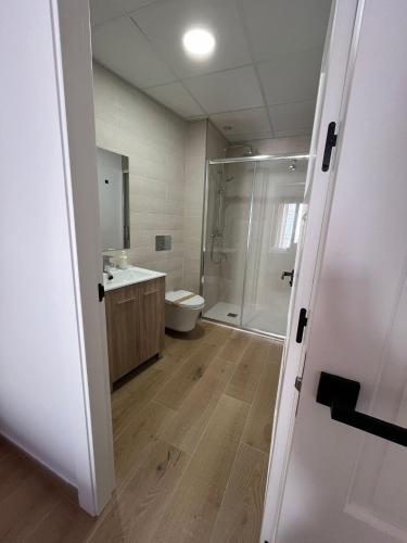 a bathroom with a shower and a toilet and a sink at Via Caprasia Alojamiento Rural in Villargordo del Cabriel