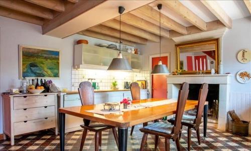une cuisine avec une table et des chaises en bois dans l'établissement Le Logis Viennois - A 20 km de Center Parcs, à Sammarçolles