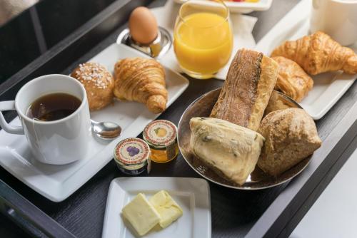 a tray of breakfast food with a cup of coffee and pastries at Hôtel Saint-Louis - Jardin du Luxembourg in Paris