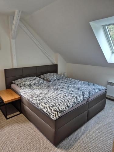 sypialnia z łóżkiem w pokoju z oknem w obiekcie Apartmans Les w Zlinie