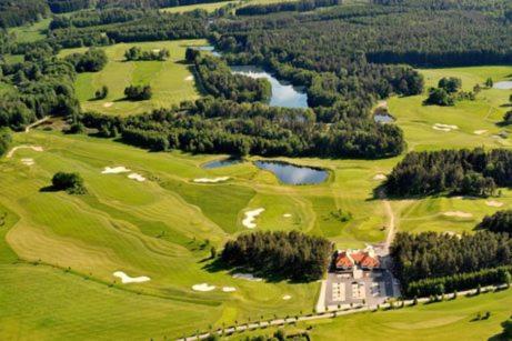 an aerial view of a golf course with a house at Vila u potoka in Jindrichuv Hradec