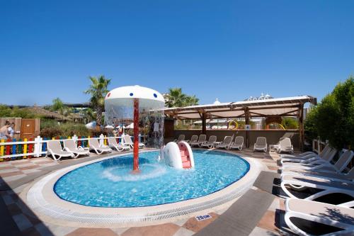 a swimming pool with an umbrella and lounge chairs at Adalya Elite Lara Hotel - Ultra All Inclusive in Lara