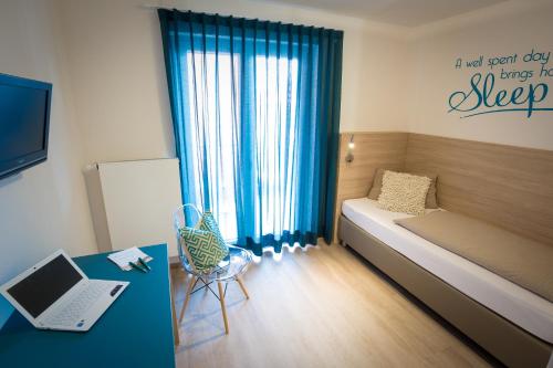 a bedroom with a bed and a desk with a laptop at Hotel Landgasthof zum Kaffelstein in Kreuzwertheim