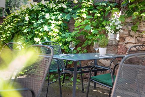 a table with chairs and wine glasses on it at Hotel Landgasthof zum Kaffelstein in Kreuzwertheim