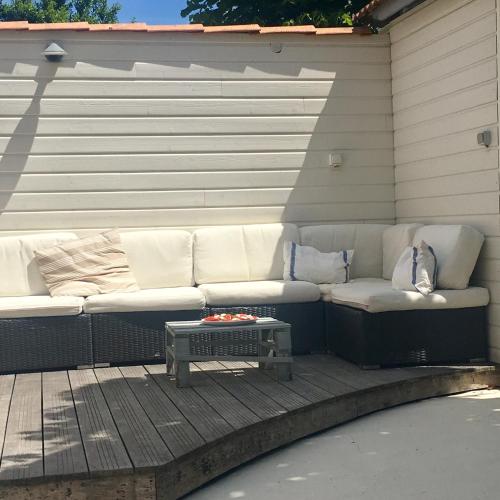 - un canapé blanc installé sur une terrasse avec une table dans l'établissement Maison Royan Pontaillac 300m de la plage, à Royan