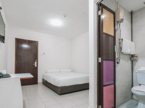 a bedroom with a bed and a bathroom with a toilet at A Hotel Desker, Stay from 10PM to 9AM in Singapore