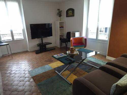 un salon avec un canapé, une table et une télévision dans l'établissement SanYo, à Briare