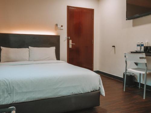 a bedroom with a bed and a desk and a door at A Hotel Desker, Stay from 10PM to 9AM in Singapore