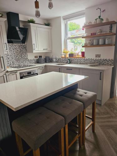 a kitchen with a white counter top and a table at House in central winchester in Winchester