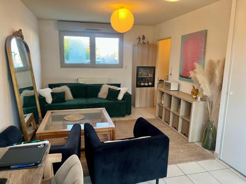 un salon avec un canapé vert et une table dans l'établissement Pablo house - 24h du mans, au Mans