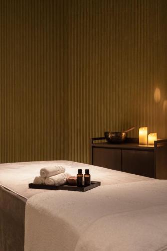 a bedroom with a bed with two towels and candles at Lamore Hotel Đà Nẵng in Danang