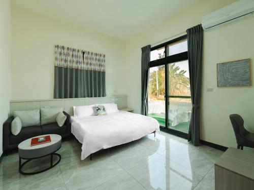 a bedroom with a white bed and a couch at Maimai B&B, Ganluyuan in Tung-chou