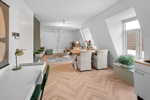 a dining room and living room with a table and chairs at Unique Penthouse Near City Center And Park in Roosendaal