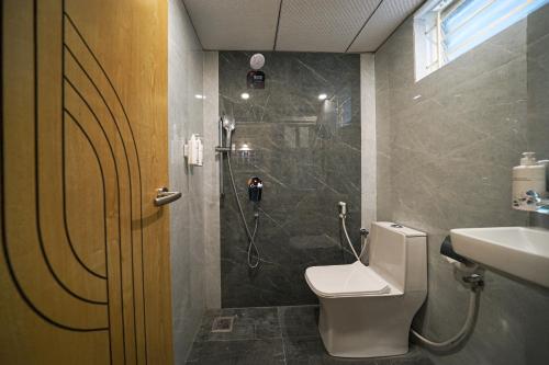 a bathroom with a shower and a toilet and a sink at Olive Hotel Kundalahalli by Embassy Group in Bengaluru