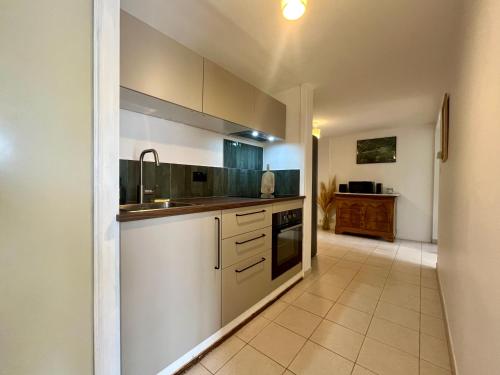 une cuisine avec des armoires blanches et un évier dans l'établissement Grand Lodge, à Pierrevert