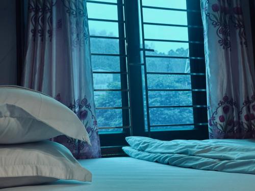 a bedroom with a bed with pillows and a window at Bình An Hostel in Dồng Văn