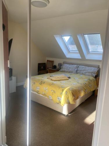 a bedroom with a bed with yellow sheets and skylights at 30 College Street, Buckhaven, Leven, Fife, KY81JX in Buckhaven