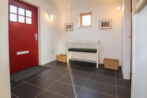 a room with a red door and a small bedroom at Loch View in Breaclete