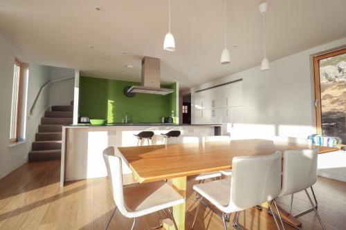 a kitchen and dining room with a wooden table and chairs at Loch View in Breaclete