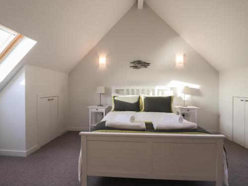 a bedroom with a white bed in a attic at Loch View in Breaclete