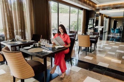 a woman sitting at a table with a laptop at Áurea Washington Irving by Eurostars Hotel Company in Granada