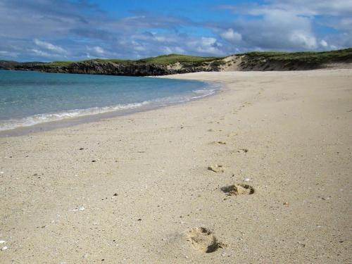 a pair of footprints in the sand on a beach at Loch View in Breaclete