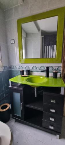 a bathroom with a green sink and a mirror at El Balcón de Valles in Reocín