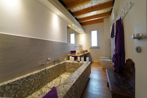a bathroom with a tub and a toilet at Villa Podere Gaia 16 Pax by VILLASRETREATS in Sasseta