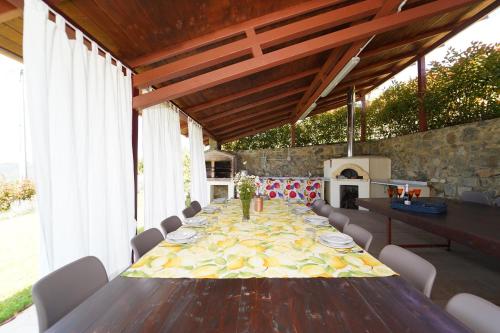 a dining table with chairs and a stone wall at Villa Podere Gaia 16 Pax by VILLASRETREATS in Sasseta