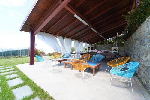 a group of chairs and tables on a patio at Villa Podere Gaia 16 Pax by VILLASRETREATS in Sasseta