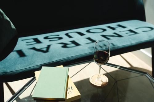 a glass of wine on a table next to a chair at The Central House Lisbon Baixa in Lisbon