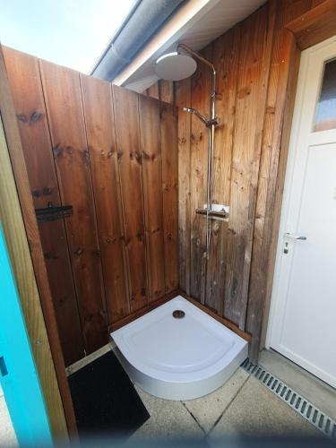 La salle de bains est pourvue de toilettes et d'un mur en bois. dans l'établissement Cabane des randonneurs, jardin, Bassin d'Arcachon, au Teich