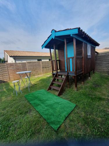 une petite maison avec une table de pique-nique et une table dans l'établissement Cabane des randonneurs, jardin, Bassin d'Arcachon, au Teich