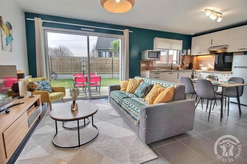 un salon avec un canapé et une cuisine dans l'établissement La nelliere 1, à Saint-Cast-le-Guildo