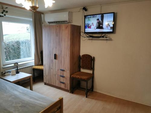 a bedroom with a bed and a tv on the wall at Na Kopitarjevi in Laško