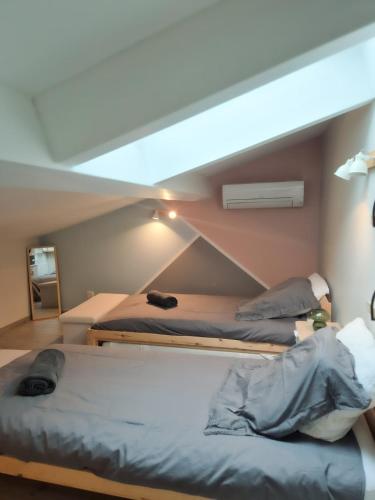 two beds in a room with a roof at Villa Élégante à Berre-les-Alpes - Terrasse, Piscine & Vue Panoramique in Berre-les Alpes