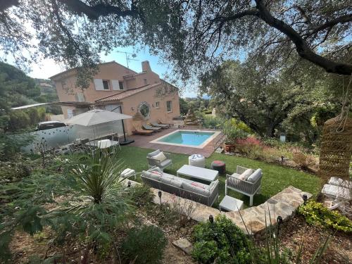 une maison avec une piscine en face d'une cour dans l'établissement Villa avec piscine vue mer 4 chambres à Saint-Clair Le Lavandou, à La Celle-sous-Gouzon