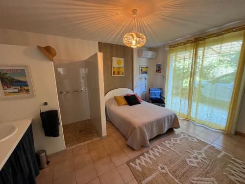 une chambre avec un lit et un lustre dans l'établissement Villa avec piscine vue mer 4 chambres à Saint-Clair Le Lavandou, à La Celle-sous-Gouzon