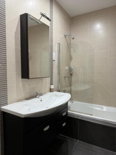 une salle de bain avec un lavabo blanc et une douche dans l'établissement Sliema 1BDR Apartment with Pool Access and off Seafront, à Sliema
