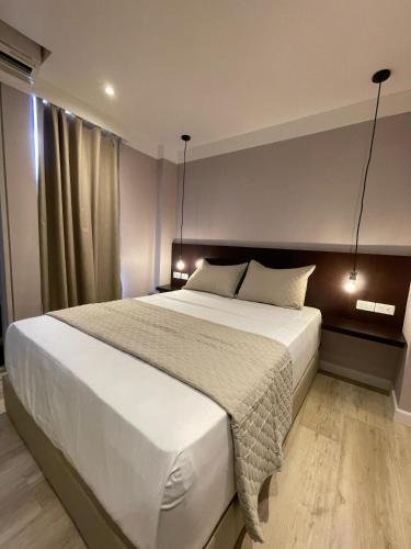 a bedroom with a large white bed with two lamps at Hotel Grand Galaxie in Caracas