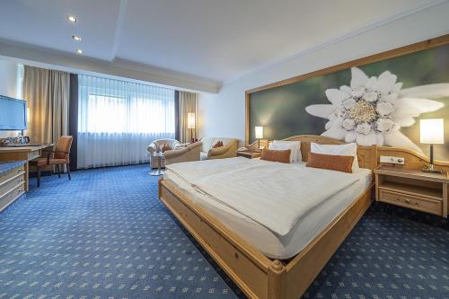 a hotel room with a large bed and a desk at EUROPÄISCHER HOF Bad Gastein in Bad Gastein