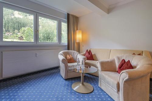 a living room with a couch and two chairs and a table at EUROPÄISCHER HOF Bad Gastein in Bad Gastein