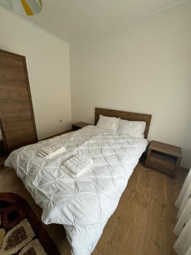 a bedroom with a large white bed with two tables at Edy Central Apartment in Arad