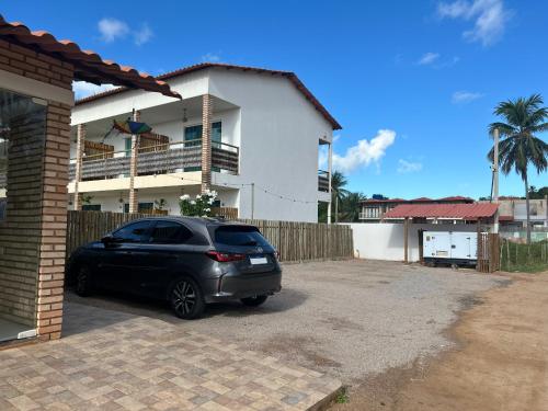 a car parked in front of a house at Pousada Estação do Mar in Japaratinga